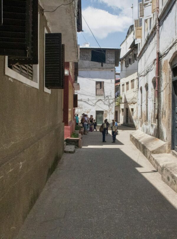 a narrow street with people walking down it