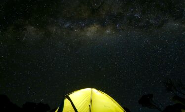 yellow tent under black sky during nighttime