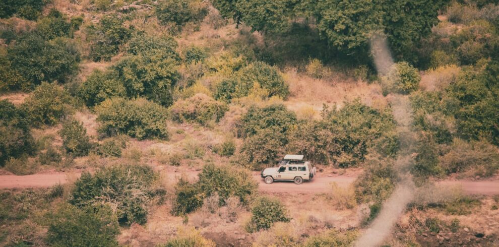 a van is parked in the middle of a dirt road