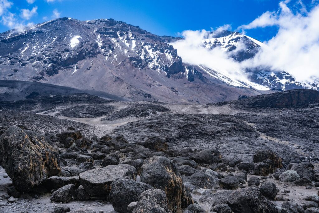 a rocky area with snow covered mountains